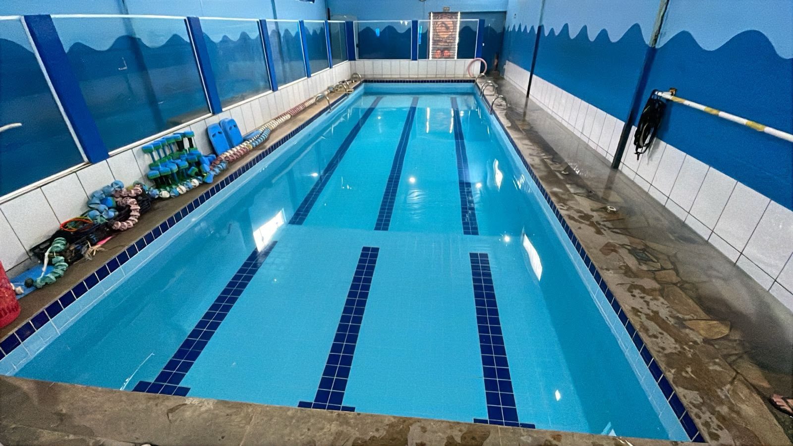Piscina da Aquatic Itapeva, com as raias marcadas no fundo e o material de aula na borda